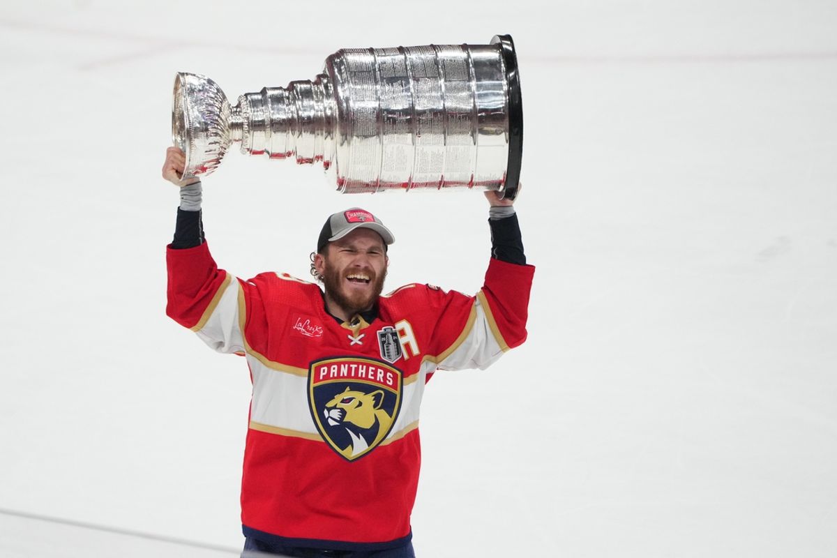 Jun 24, 2024; Sunrise, Florida, USA; Florida Panthers forward Matthew Tkachuk (19) hoists the Stanley Cup after defeating Edmonton Oilers in game seven of the 2024 Stanley Cup Final at Amerant Bank Arena. Mandatory Credit: Jim Rassol-Imagn Images