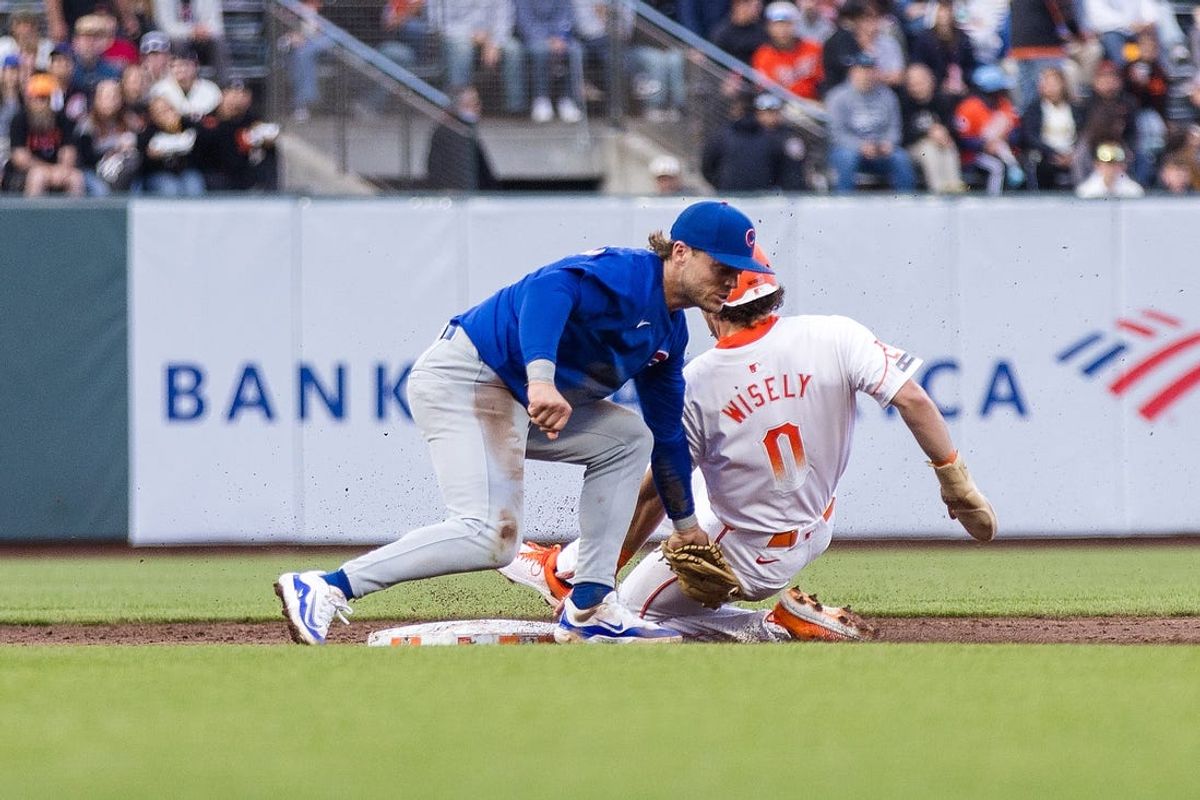 Jun 25, 2024; San Francisco, California, USA; San Francisco Giants shortstop Brett Wisely (0) is tagged by Chicago Cubs second baseman Nico Hoerner (2) after a steal attempt during the third inning at Oracle Park. Mandatory Credit: John Hefti-USA TODAY Sports