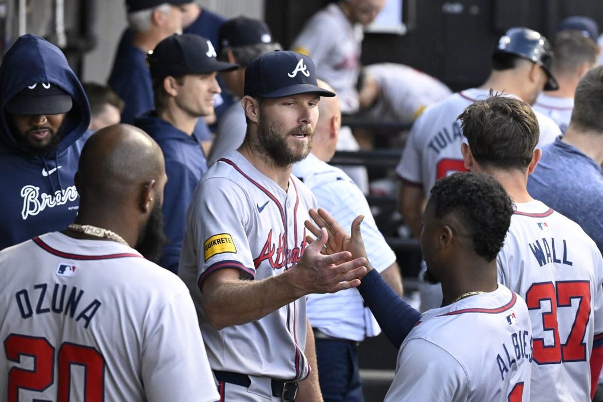 Jun 27, 2024; Chicago, Illinois, USA; Atlanta Braves pitcher Chris Sale (center) high fives teammates in the dugout after finishing the seventh inning against the Chicago White Sox at Guaranteed Rate Field. Mandatory Credit: Matt Marton-USA TODAY Sports