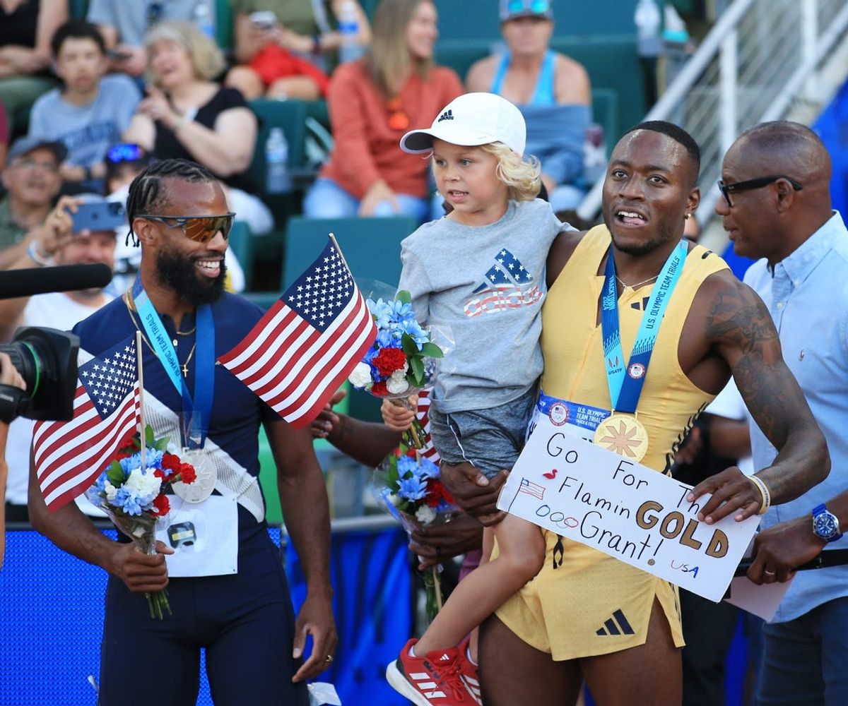 Grant Holloway, right, carries six-year-old Chase Barreau as he joins Freddie Crittenden, left, in celebration after winning the men’s 110-hurdle during day 8 of the U.S. Olympic Track and Field Trials at Hayward Field in Eugene Friday, June 28, 2024.