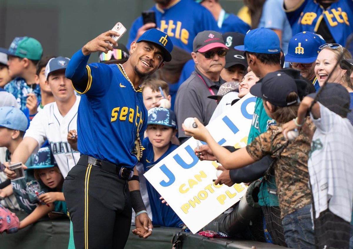 Jun 28, 2024; Seattle, Washington, USA; Seattle Mariners centerfielder Julio Rodriguez (44) takes a selfie with fan before a game against the Minnesota Twins at T-Mobile Park. Mandatory Credit: Stephen Brashear-USA TODAY Sports