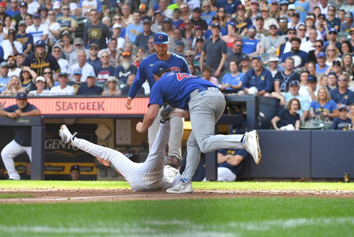 Jun 29, 2024; Milwaukee, Wisconsin, USA; Milwaukee Brewers second baseman Andruw Monasterio (14) is tagged out by Chicago Cubs relief pitcher Tyson Miller (49) after a rundown in the seventh inning at American Family Field. Mandatory Credit: Michael McLoone-USA TODAY Sports