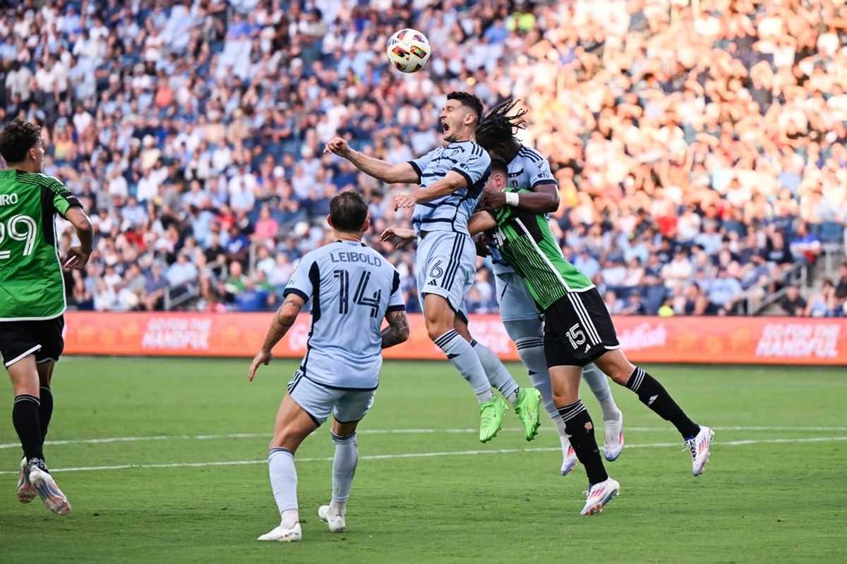 Jun 29, 2024; Kansas City, Kansas, USA; Sporting Kansas City midfielder Erik Thommy (26) and Austin FC defender Leo Vaisanen (15) battle for the ball during the first half at Children's Mercy Park. Mandatory Credit: David Rainey-USA TODAY Sports