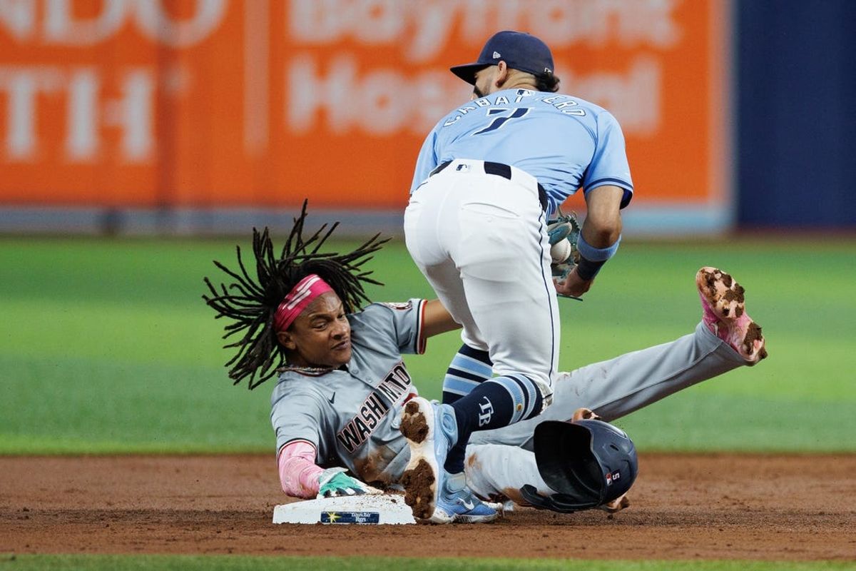Jun 30, 2024; St. Petersburg, Florida, USA;  Washington Nationals shortstop CJ Abrams (5) steals second base from Tampa Bay Rays shortstop Jose Caballero (7) in the third inning at Tropicana Field. Mandatory Credit: Nathan Ray Seebeck-USA TODAY Sports