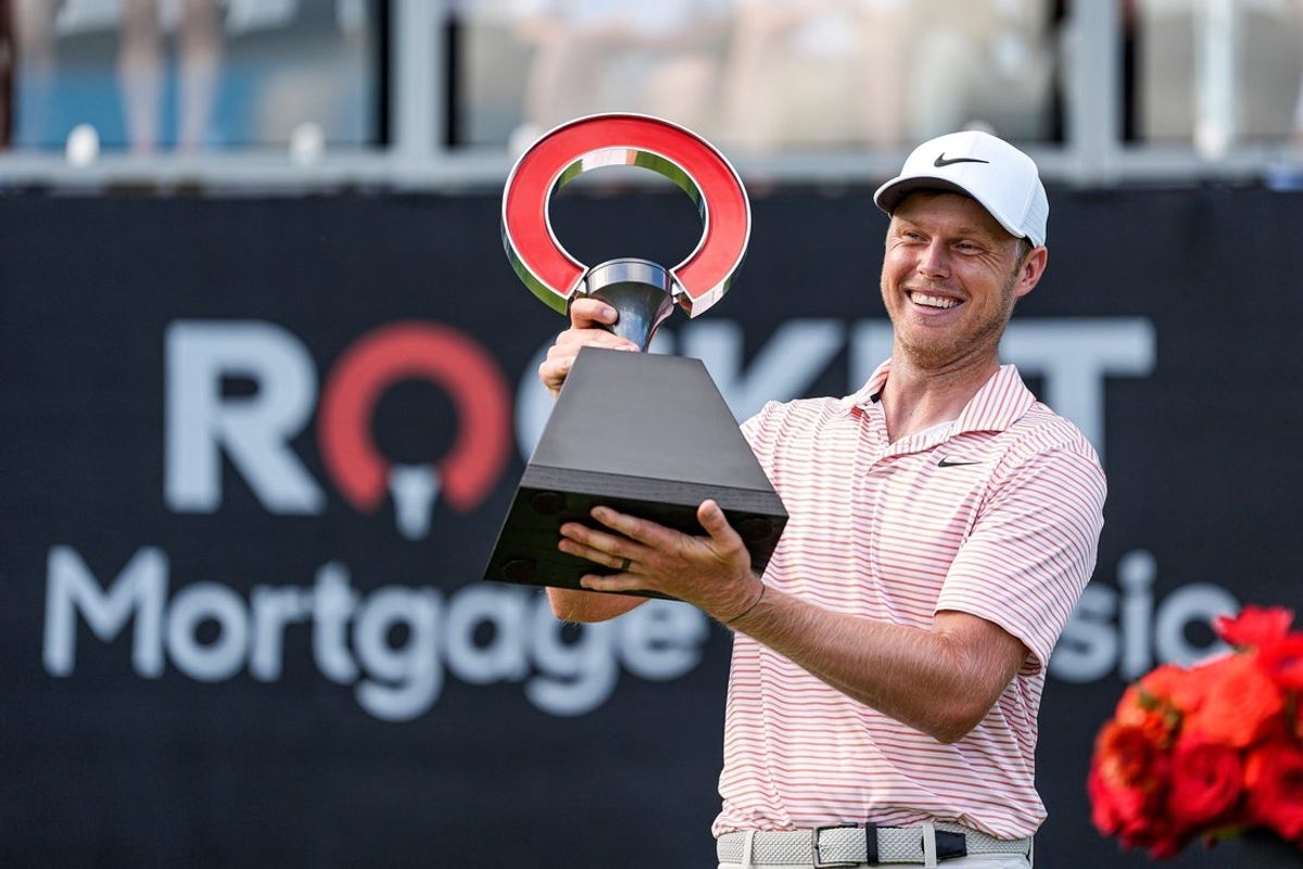 Cam Davis lifts up the trophy to celebrate winning Rocket Mortgage Classic at Detroit Golf Club in Detroit on Sunday, June 30, 2024.