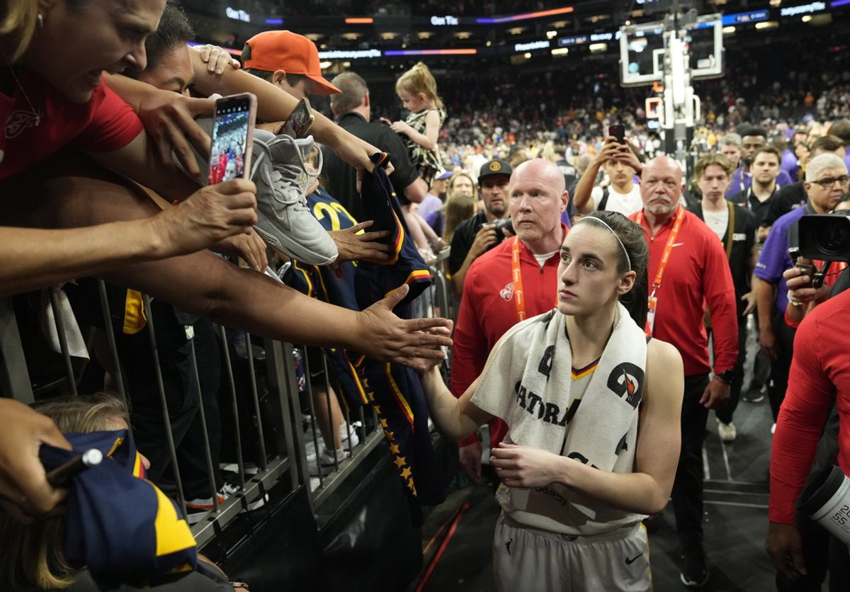 Jun 30, 2024; Phoenix, Ariz., U.S.; Indiana Fever guard Caitlin Clark (22) signs autographs for fans after beating the Phoenix Mercury 88-82 at Footprint Center. Mandatory Credit: Michael Chow-Arizona Republic