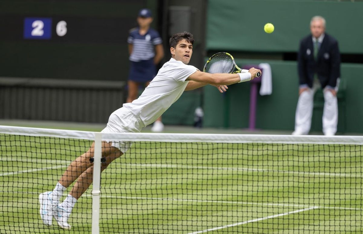 Jul 1, 2024; London, United Kingdom; Carlos Alcaraz of Spain returns a shot during his match against Mark Lajal of Estonia (not shown) on day one of The Championships at All England Lawn Tennis and Croquet Club. Mandatory Credit: Susan Mullane-USA TODAY Sports