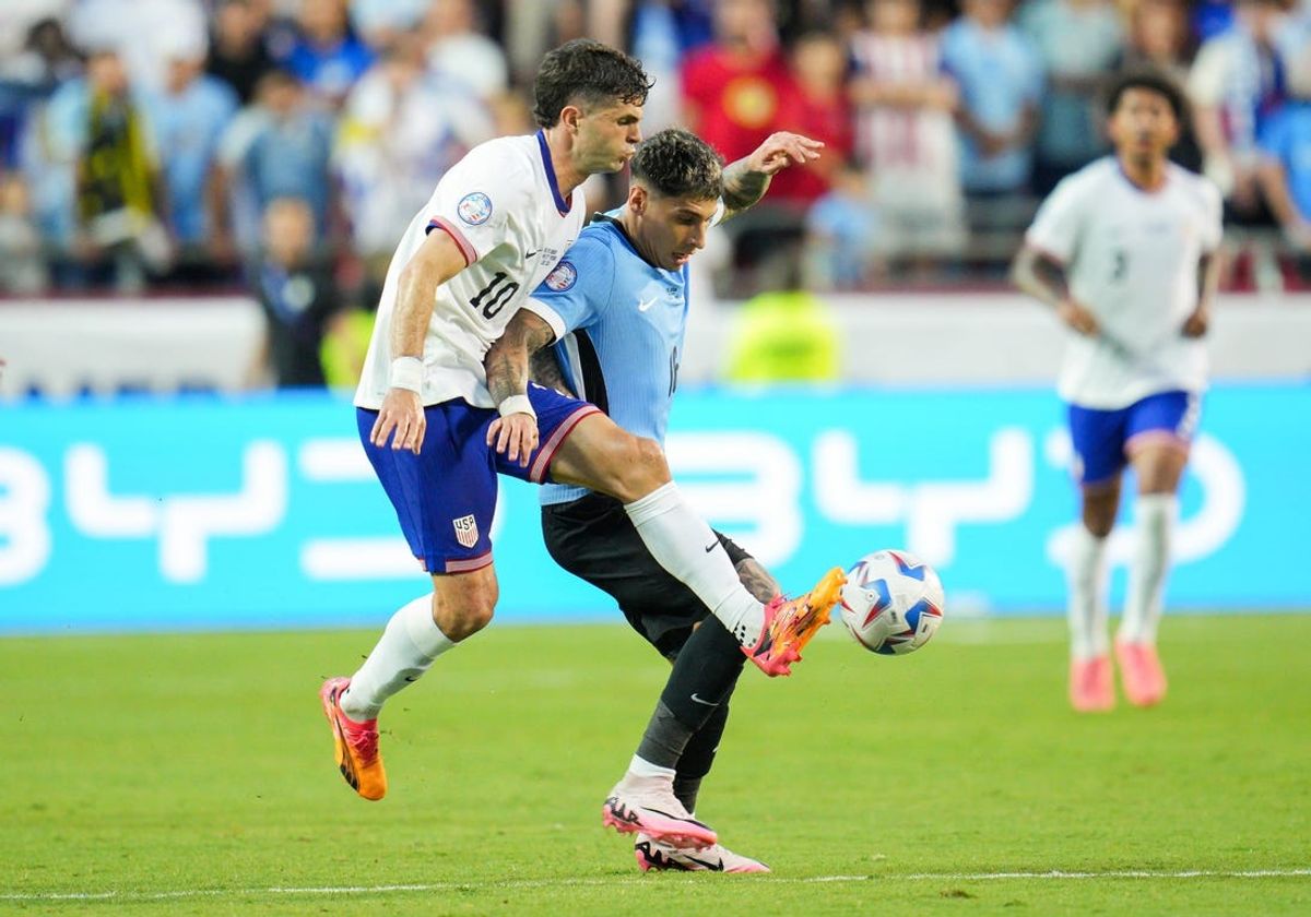 Jul 1, 2024; Kansas City, Missouri, USA; United States forward Christian Pulisic (10) and Uruguay defender Mathias Olivera (16) fight for the ball during the first half of a Copa America match at Arrowhead Stadium. Mandatory Credit: Jay Biggerstaff-USA TODAY Sports