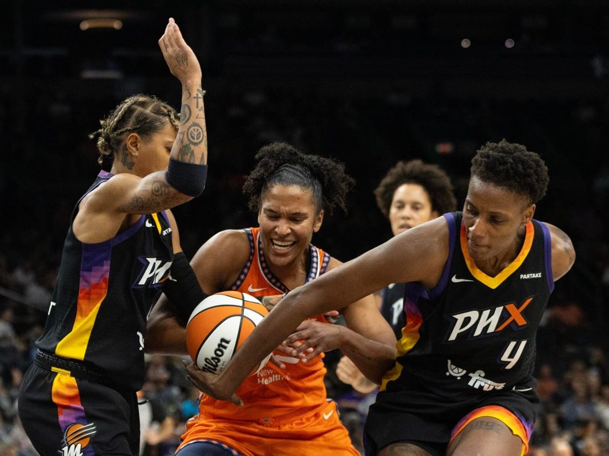 Phoenix Mercury forward Natasha Mack (4) gets her hand on the ball while Connecticut Sun forward Alyssa Thomas (25) drives in the paint on July 1, 2024 at Footprint Center in Phoenix.