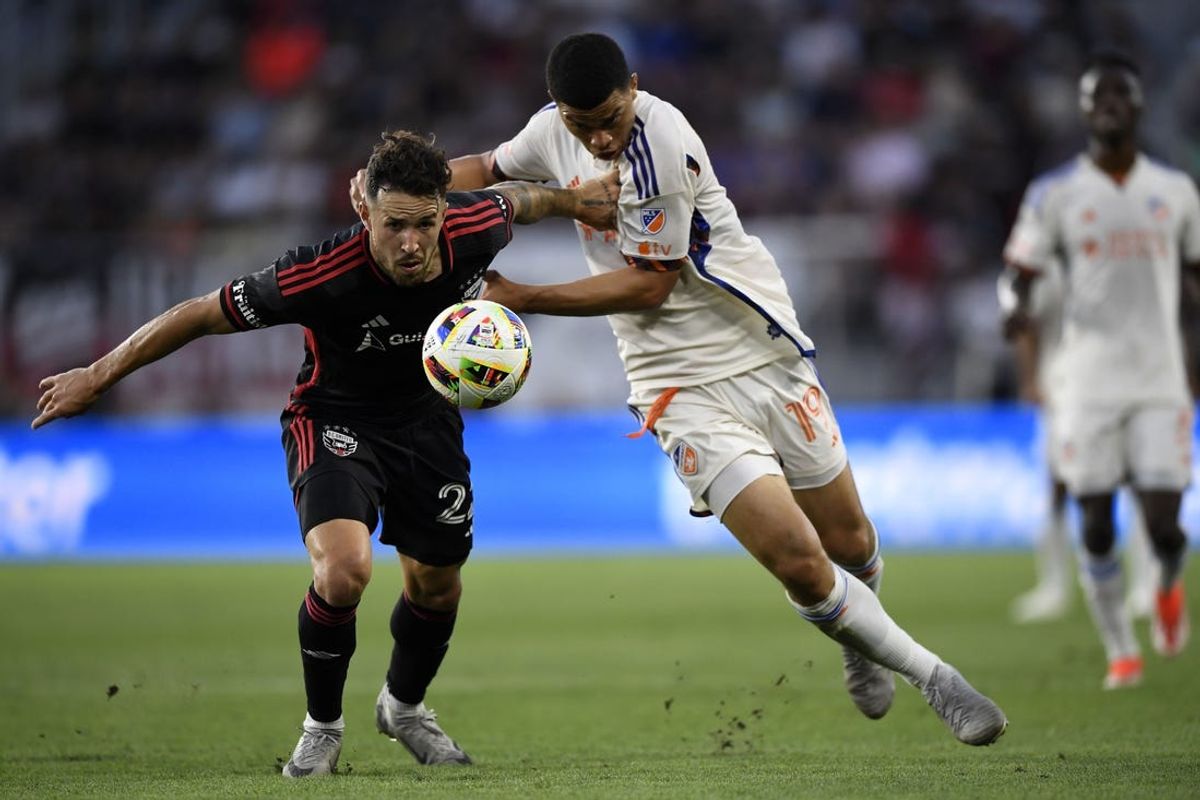Jul 3, 2024; Washington, District of Columbia, USA; D.C. United defender Aaron Herrera (22) and FC Cincinnati defender Kevin Kelsy (19) attempt to get to a ball during the first half at Audi Field. Mandatory Credit: Hannah Foslien-USA TODAY Sports