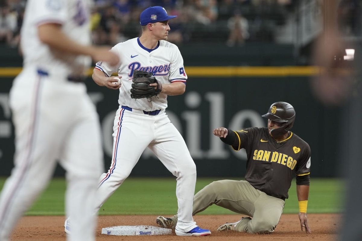 Jul 3, 2024; Arlington, Texas, USA; Texas Rangers shortstop Corey Seager (5) forces out San Diego Padres designated hitter Donovan Solano (39) at second base during the second inning at Globe Life Field. Mandatory Credit: Jim Cowsert-USA TODAY Sports
