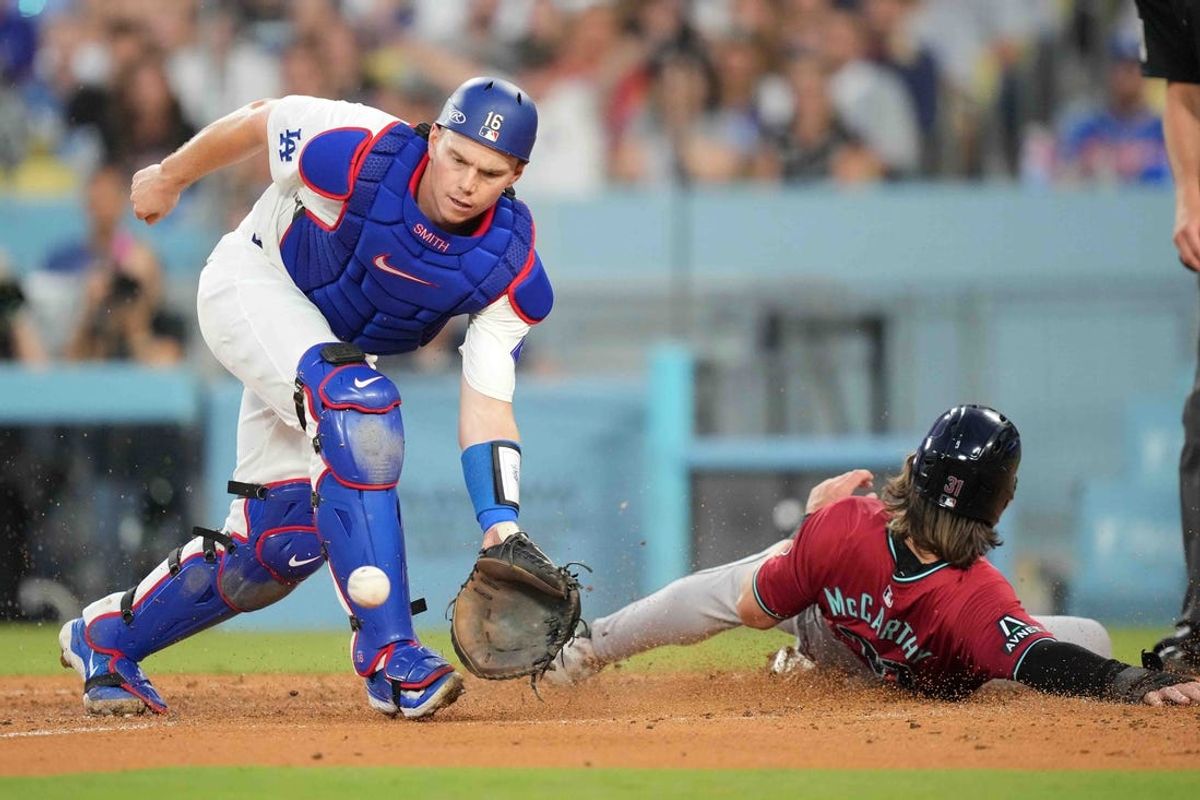 Jul 3, 2024; Los Angeles, California, USA; Arizona Diamondbacks right fielder Jake McCarthy (31) slides into home plate to beat a throw to Los Angeles Dodgers catcher Will Smith (16) to score in the third inning at Dodger Stadium. Mandatory Credit: Kirby Lee-USA TODAY Sports