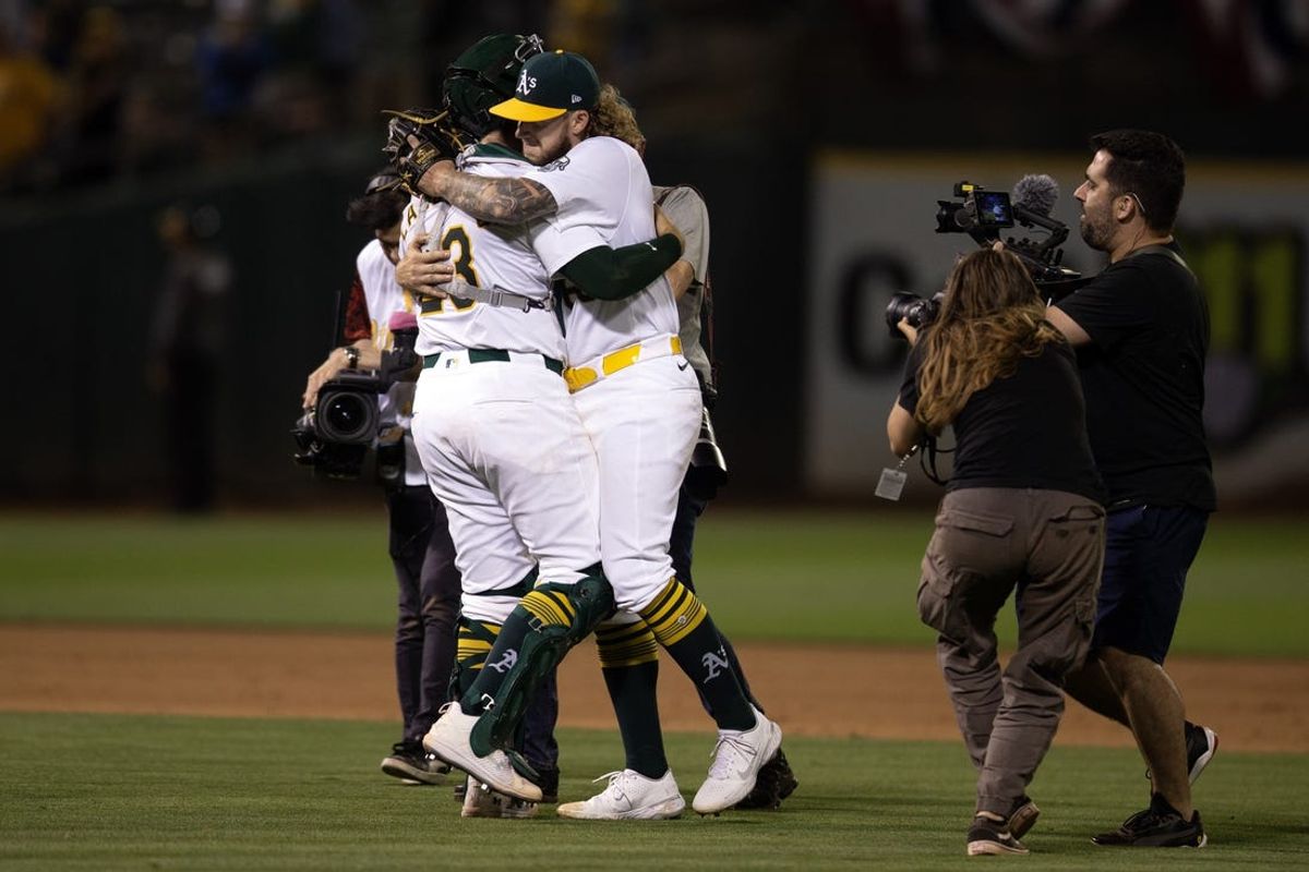 Jul 3, 2024; Oakland, California, USA; Oakland Athletics starting pitcher Joey Estes (right) hugs his catcher Shea Langeliers (23), after pitching a complete game shutout against the Los Angeles Angels at Oakland-Alameda County Coliseum. Mandatory Credit: D. Ross Cameron-USA TODAY Sports