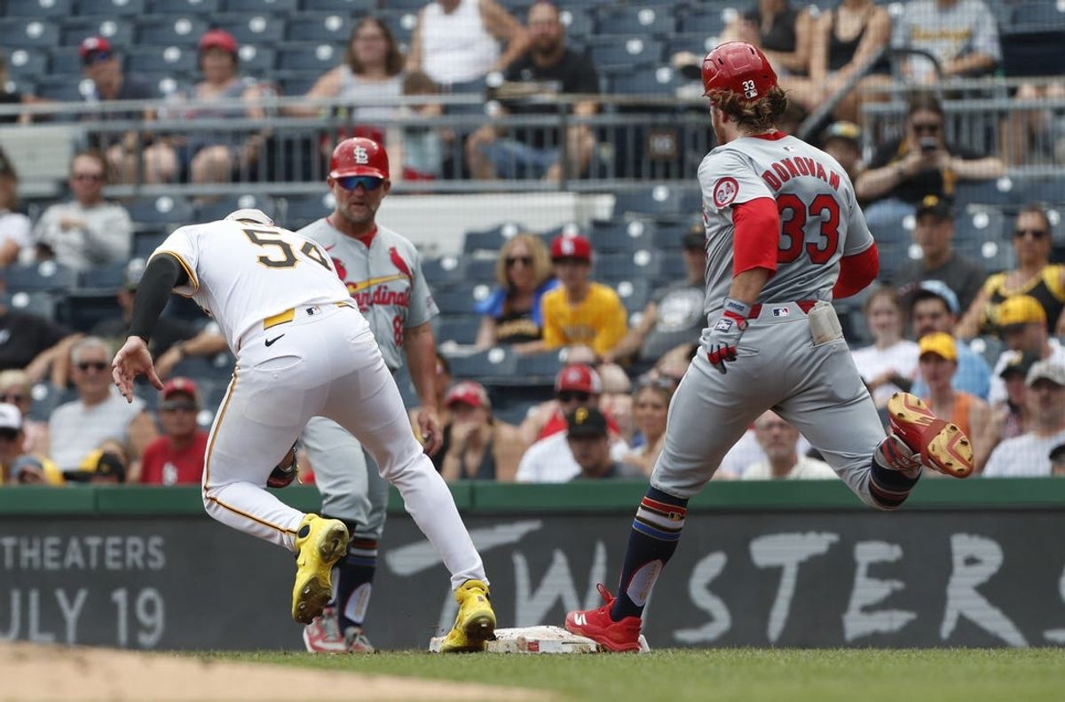Jul 4, 2024; Pittsburgh, Pennsylvania, USA; St. Louis Cardinals left fielder Brendan Donovan (33) beats a throw to Pittsburgh Pirates starting pitcher Martín Pérez (54) to reach base during the second inning at PNC Park. Mandatory Credit: Charles LeClaire-USA TODAY Sports