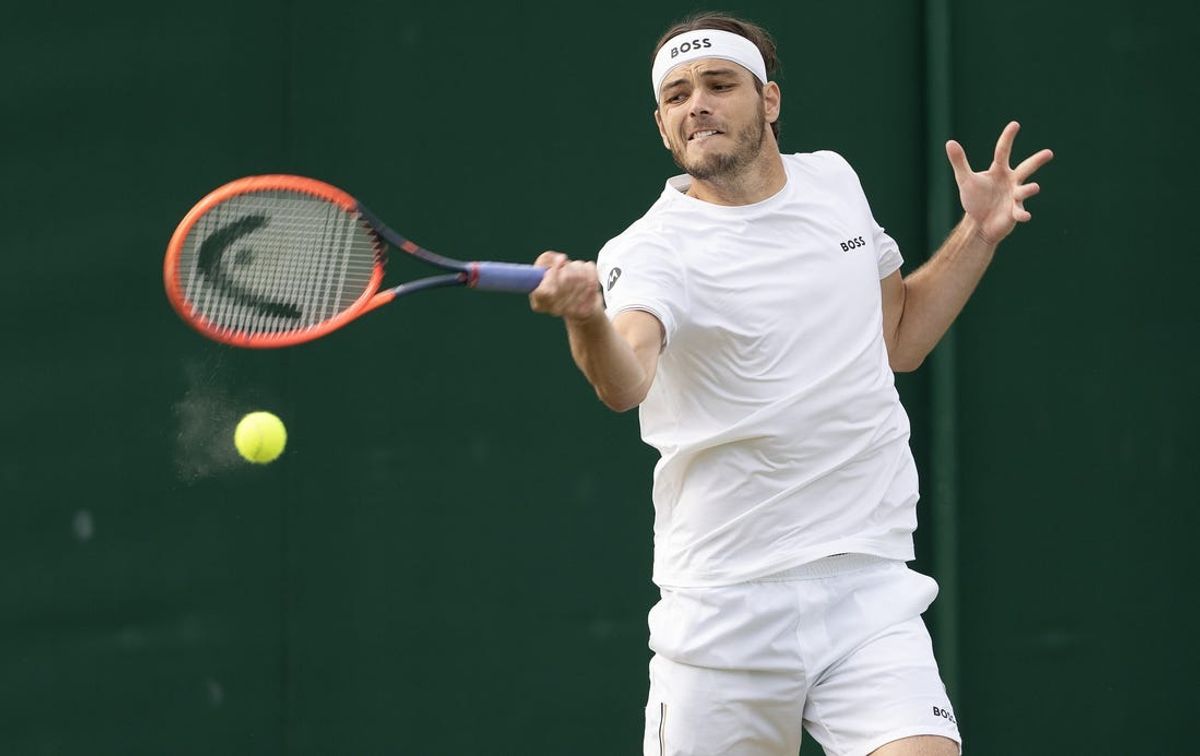 Jul 4, 2024; London,United Kingdom; Taylor Fritz of the United States returns a shot during his match against Arthur Rinderknech of France (not shown) on day four of The Championships at All England Lawn Tennis and Croquet Club. Mandatory Credit: Susan Mullane-USA TODAY Sports