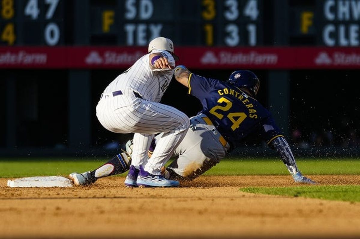 Jul 4, 2024; Denver, Colorado, USA; Milwaukee Brewers catcher William Contreras (24) slides into send base and is tagged out by Colorado Rockies shortstop Ezequiel Tovar (14) during the fifth inning at Coors Field. Mandatory Credit: Troy Babbitt-USA TODAY Sports