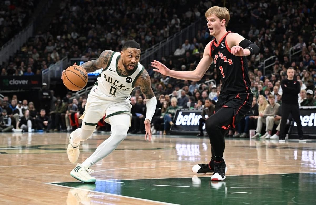 Apr 5, 2024; Milwaukee, Wisconsin, USA; Milwaukee Bucks guard Damian Lillard (0) drives to the basket against Toronto Raptors guard Gradey Dick (1) in the second half at Fiserv Forum.
