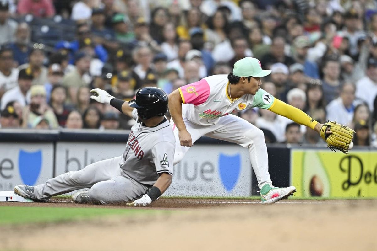 July 5, 2024; San Diego, California, USA; Arizona Diamondbacks catcher Gabriel Moreno (14) slides into third base ahead of throw to San Diego Padres shortstop Ha-Seong Kim (7) during the fourth inning at Petco Park. Mandatory Credit: Denis Poroy-USA TODAY