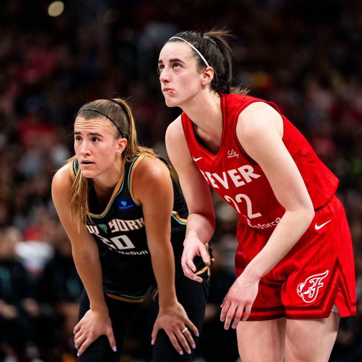 New York Liberty guard Sabrina Ionescu (20) and Indiana Fever guard Caitlin Clark (22) watch a free throw Saturday, July 6, 2024, during the game at Gainbridge Fieldhouse in Indianapolis.