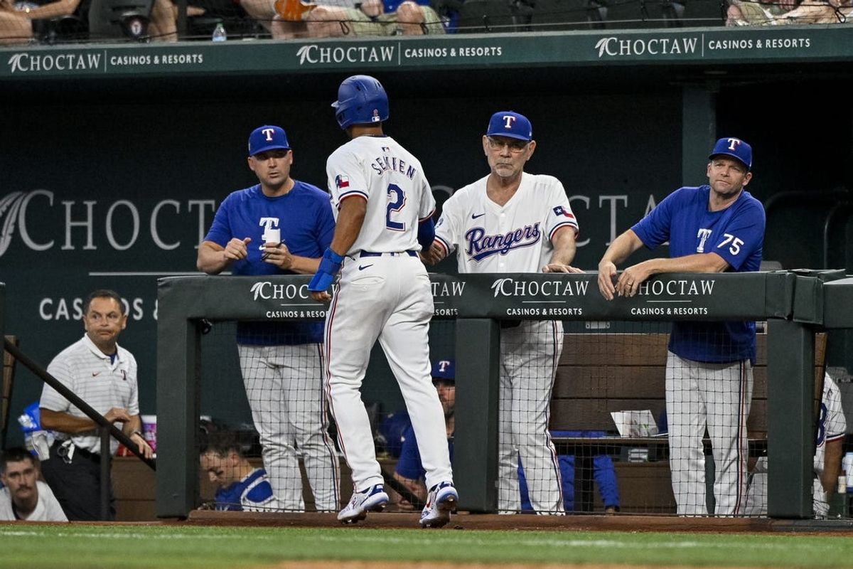 Jul 6, 2024; Arlington, Texas, USA; Texas Rangers manager Bruce Bochy (15) congratulates second baseman Marcus Semien (2) after Semien scores against the Tampa Bay Rays during the third inning at Globe Life Field. Mandatory Credit: Jerome Miron-USA TODAY Sports
