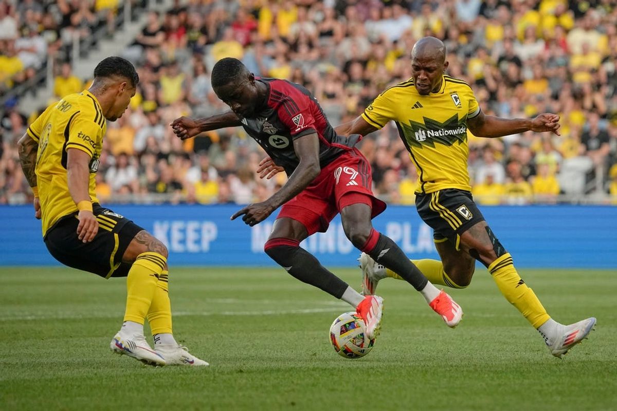 Jul 6, 2024; Columbus, OH, USA; Toronto FC forward Prince Owusu (99) tries to dribble between Columbus Crew forward Cucho Hernandez (9) and midfielder Darlington Nagbe (6) during the first half of the MLS soccer match at Lower.com Field.