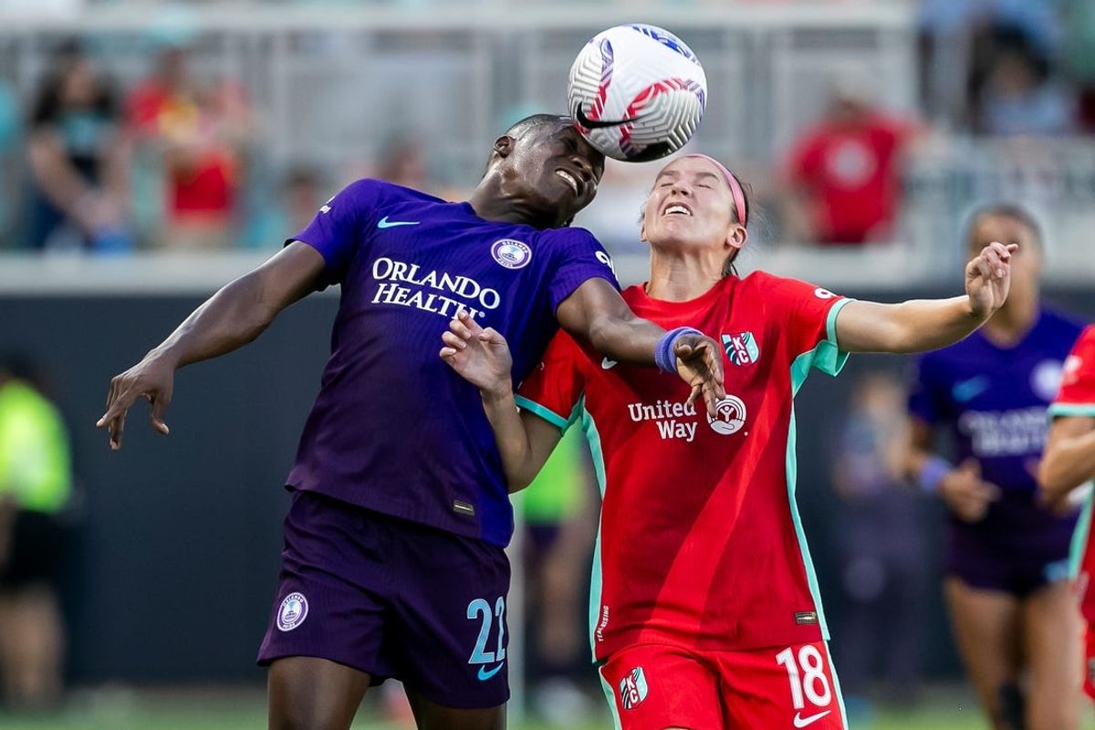 Jul 6, 2024; Kansas City, Missouri, USA; Orlando Pride forward Barbra Banda (22) and Kansas City Current defender Isabel Rodriguez (18) battle for a header during the second half at CPKC Stadium. Mandatory Credit: Nick Tre. Smith-USA TODAY Sports