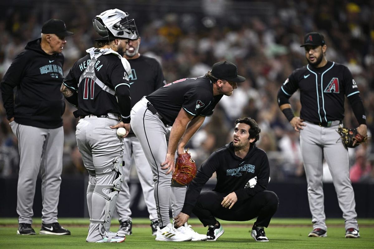Jul 6, 2024; San Diego, California, USA; Arizona Diamondbacks starting pitcher Brandon Pfaadt (32) is checked by a trainer after being hit by a batted ball during the fifth inning against the San Diego Padres at Petco Park. Mandatory Credit: Orlando Ramirez-USA TODAY Sports