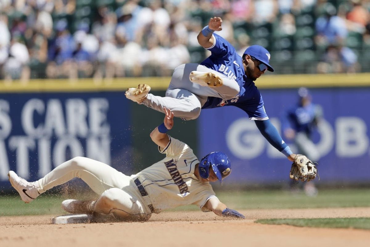 Jul 7, 2024; Seattle, Washington, USA; Seattle Mariners right fielder Dominic Canzone (8) is safe at second as Toronto Blue Jays second baseman Leo Jimenez (49) tumbles over during the fifth inning at T-Mobile Park. Mandatory Credit: John Froschauer-USA TODAY Sports