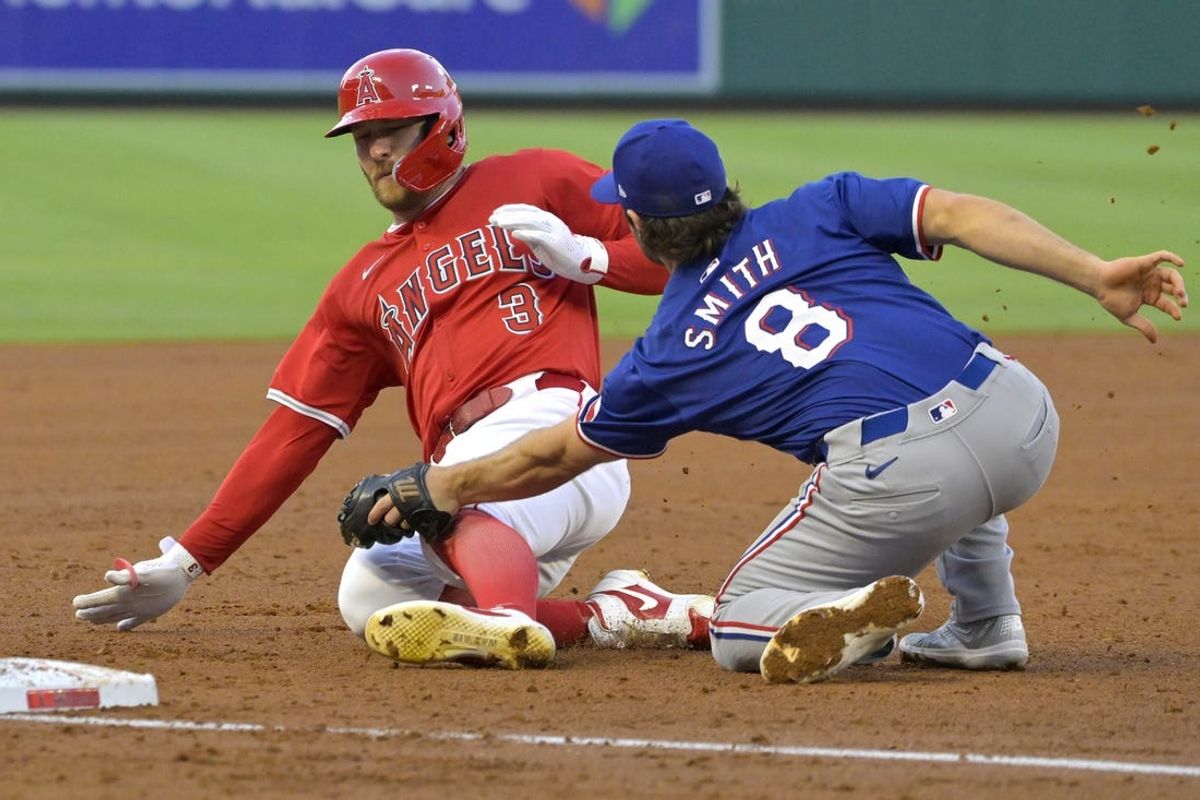 Jul 9, 2024; Anaheim, California, USA;  Los Angeles Angels left fielder Taylor Ward (3) beats the tag by Texas Rangers third baseman Josh Smith (8) on a 3-run RBI triple in the third inning at Angel Stadium. Mandatory Credit: Jayne Kamin-Oncea-USA TODAY Sports