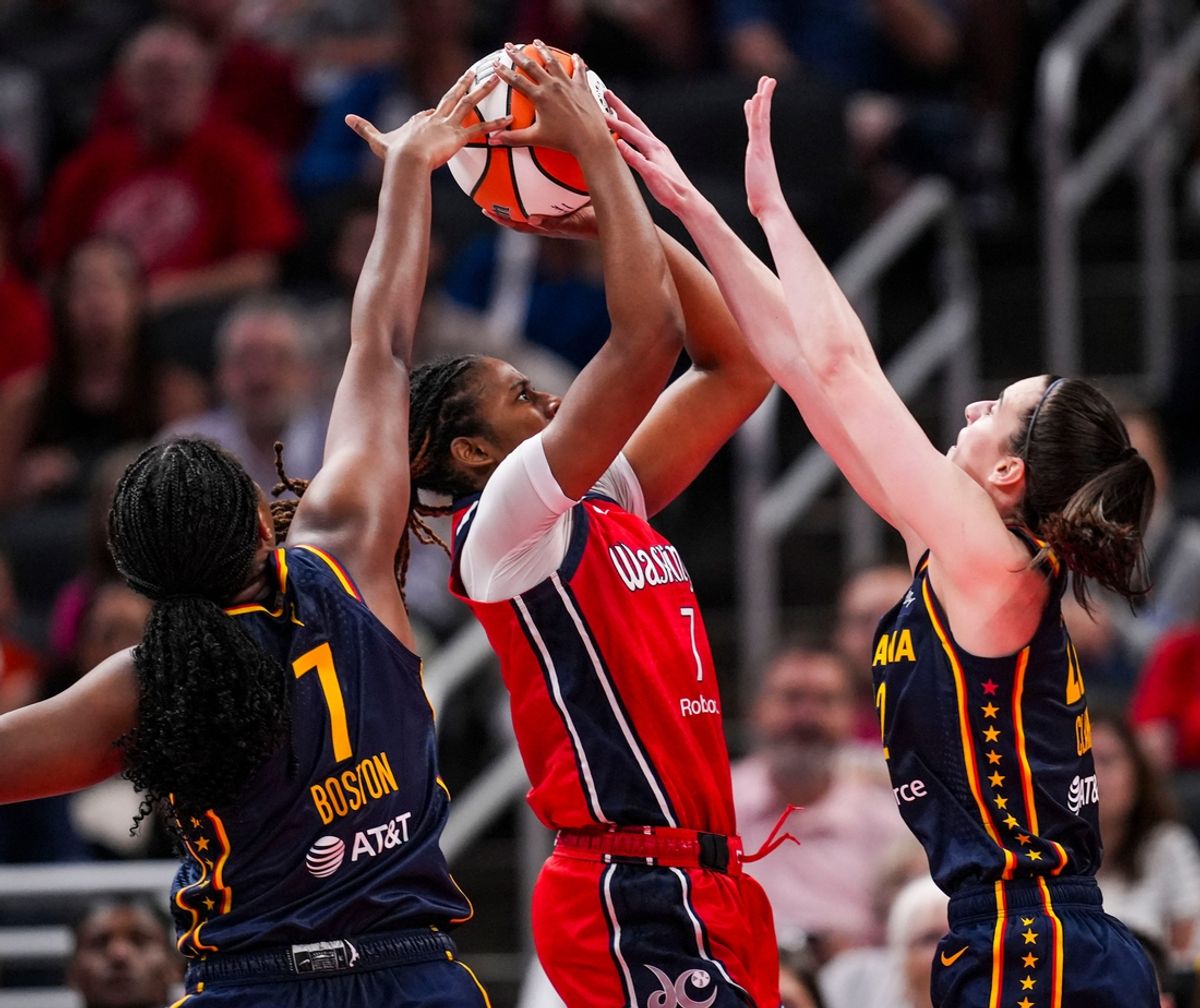 Indiana Fever forward Aliyah Boston (7) and Indiana Fever guard Caitlin Clark (22) blocks Washington Mystics guard Ariel Atkins (7) on Wednesday, July 10, 2024, during the game at Gainbridge Fieldhouse in Indianapolis. The Mystics defeated the Fever, 89-84.