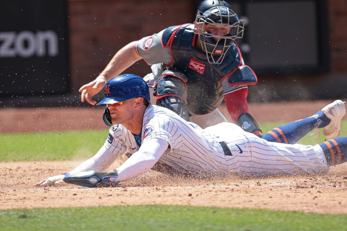 Jul 11, 2024; New York City, New York, USA; New York Mets left fielder Brandon Nimmo (9) scores a run under the tag by Washington Nationals catcher Riley Adams (15) during the fifth inning at Citi Field. Mandatory Credit: Vincent Carchietta-USA TODAY Sports