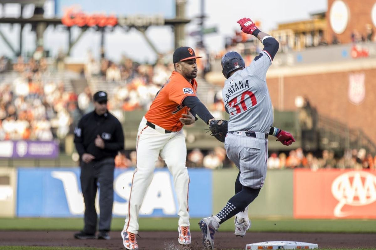 Jul 12, 2024; San Francisco, California, USA; San Francisco Giants first baseman LaMonte Wade Jr. (31) reaches for the ball to tag out Minnesota Twins first baseman Carlos Santana (30) during the first inning at Oracle Park. Mandatory Credit: John Hefti-USA TODAY Sports