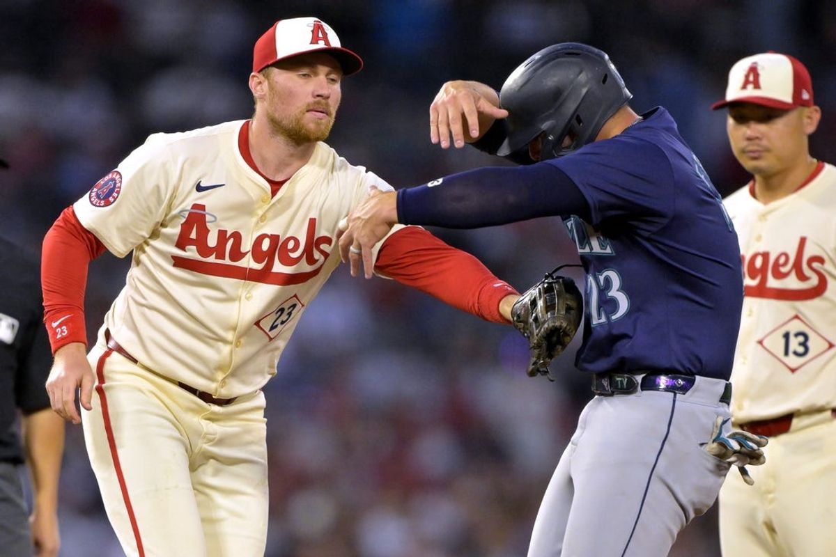 Jul 13, 2024; Anaheim, California, USA;  Ty France #23 of the Seattle Mariners is caught in a run down as he is tagged out by Brandon Drury #23 of the Los Angeles Angels in the fifth inning at Angel Stadium. Mandatory Credit: Jayne Kamin-Oncea-USA TODAY Sports