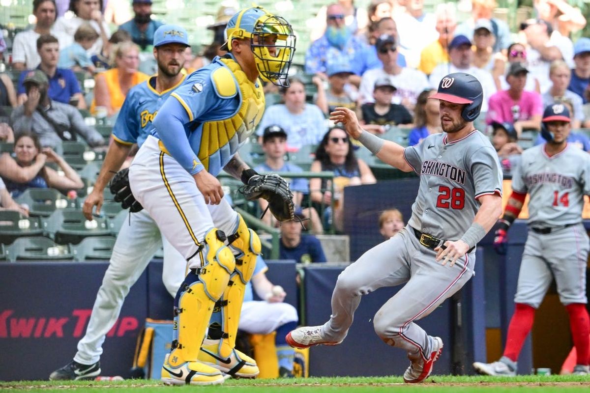 Jul 14, 2024; Milwaukee, Wisconsin, USA; Washington Nationals right fielder Lane Thomas (28) scores as Milwaukee Brewers catcher William Contreras (24) waits for the ball in the fourth inning at American Family Field. Mandatory Credit: Benny Sieu-USA TODAY Sports