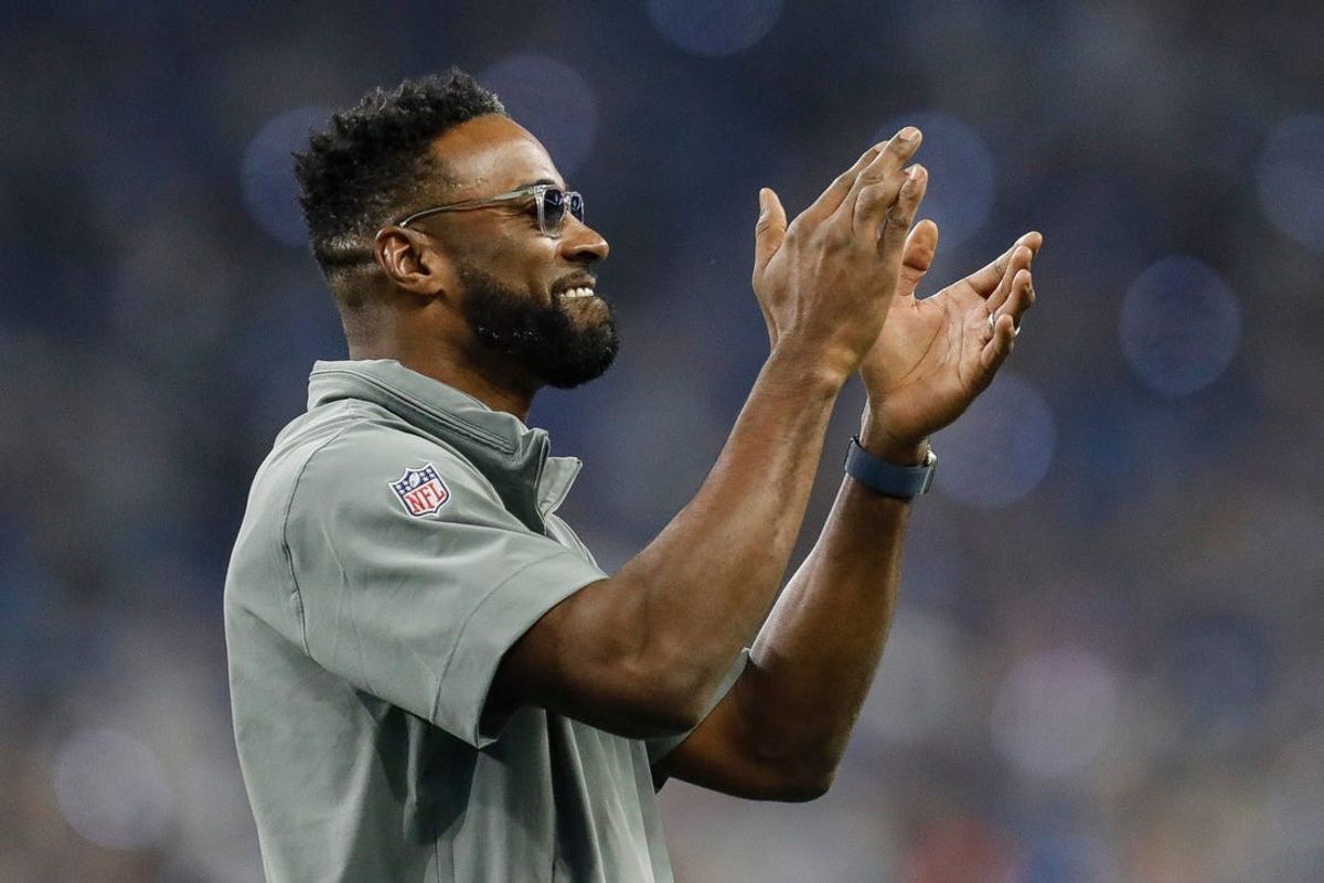 Former Detroit Lions receiver Calvin Johnson waves at fans during a January game.