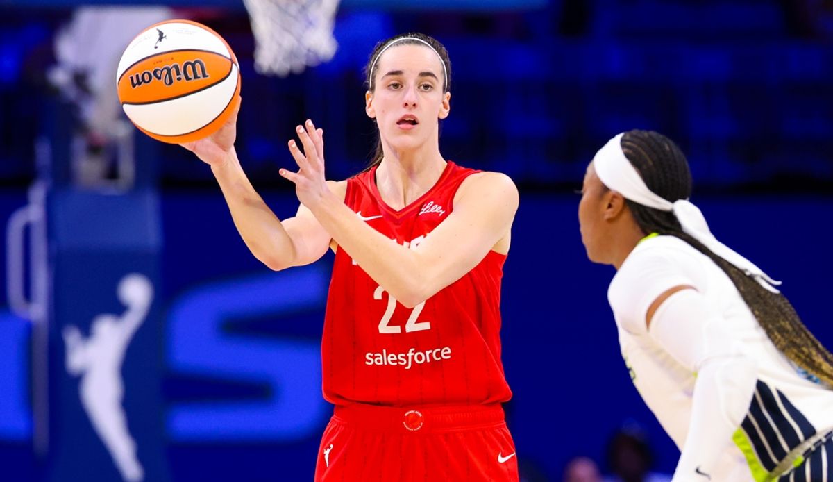 Jul 17, 2024; Arlington, Texas, USA;  Indiana Fever guard Caitlin Clark (22) passes the ball past Dallas Wings guard Odyssey Sims (2) during the second half at College Park Center. Mandatory Credit: Kevin Jairaj-Imagn Images