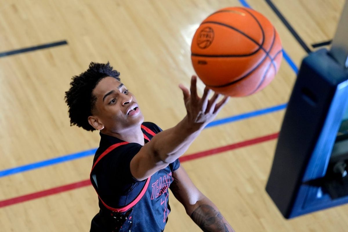 July 18, 2024; North Augusta, S.C., USA; A photographer's flash goes off as Kiyan Anthony, son of NBA star Carmelo Anthony, warms up before the Team Melo and Georgia Stars game at the Nike Peach Jam at Riverview Park Activities Center. The Georgia Stars won 64-63. Mandatory Credit: Katie Goodale-USA TODAY Network