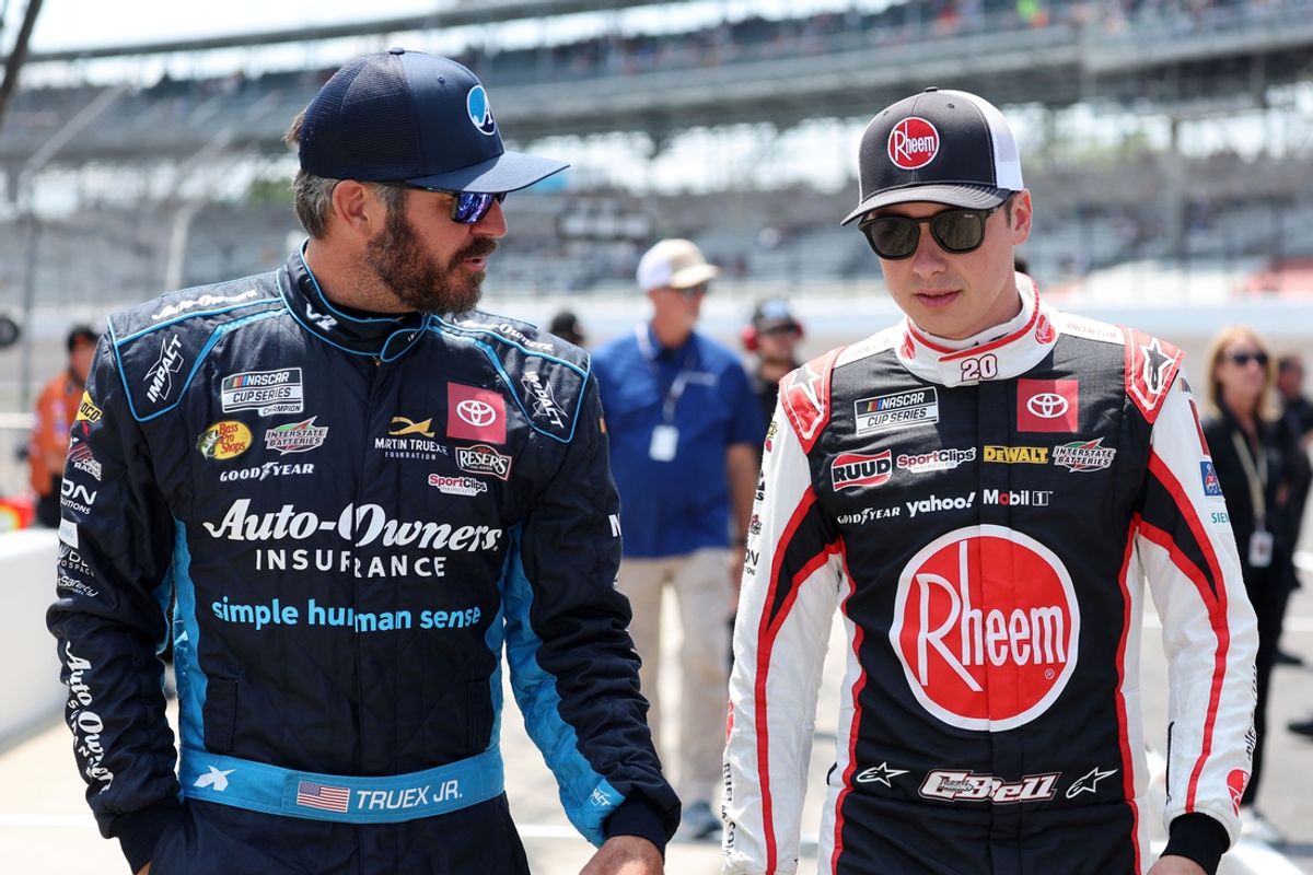 Jul 20, 2024; Indianapolis, Indiana, USA; NASCAR Cup Series driver Martin Truex Jr. (19) and  driver Christopher Bell (20) talk during qualifying for the Brickyard 400 at Indianapolis Motor Speedway. Mandatory Credit: Mike Dinovo-USA TODAY Sports