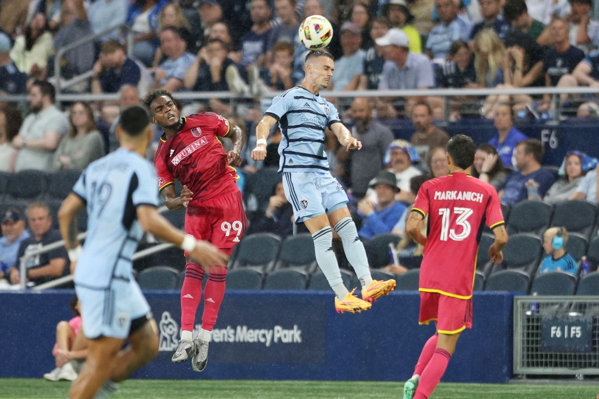 Jul 20, 2024; Kansas City, Kansas, USA; Sporting Kansas City midfielder Erik Thommy (26) heads the ball against St. Louis CITY SC forward Jayden Reid (99) in the second half at Children's Mercy Park. Mandatory Credit: William Purnell-USA TODAY Sports