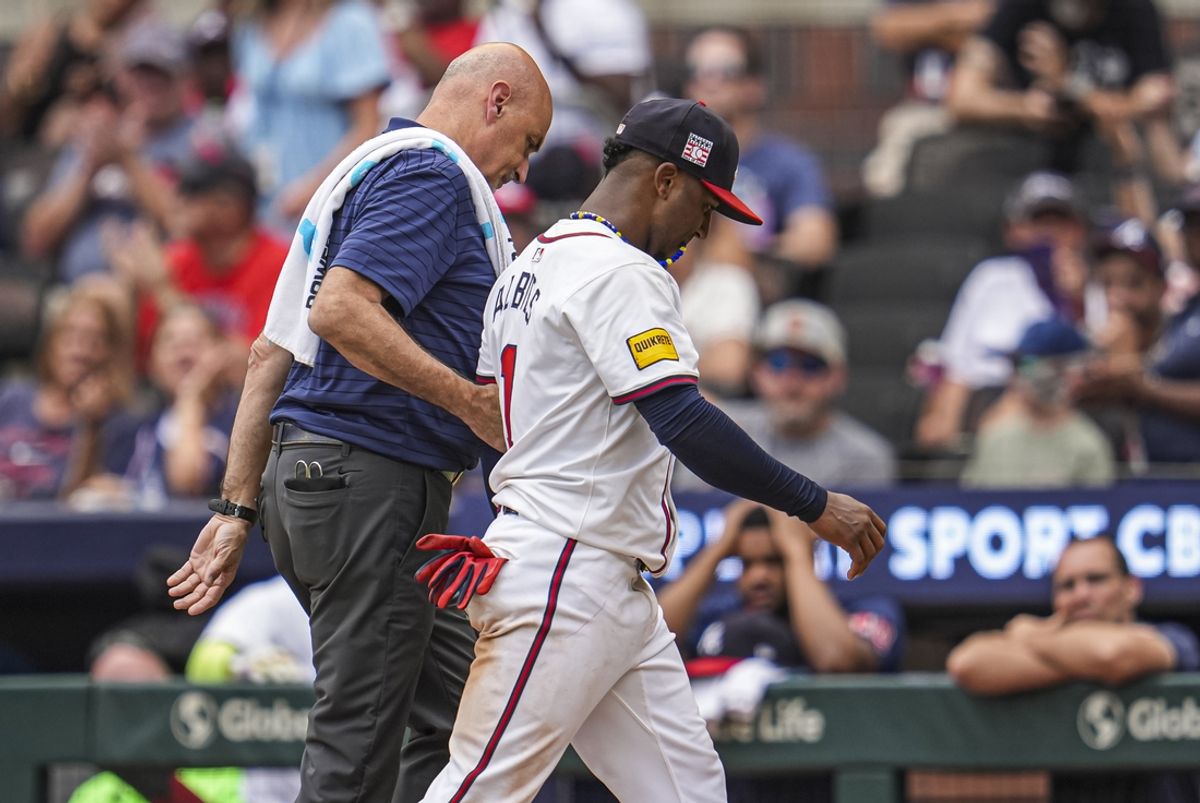 Jul 21, 2024; Cumberland, Georgia, USA; Atlanta Braves second baseman Ozzie Albies (1) is assisted off the field after being injured during a play against the St. Louis Cardinals during the ninth inning at Truist Park. Mandatory Credit: Dale Zanine-USA TODAY Sports