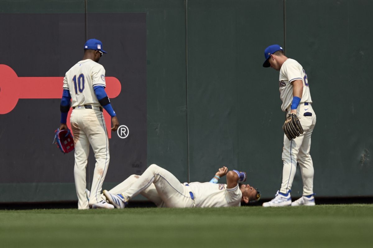 Jul 21, 2024; Seattle, Washington, USA; Seattle Mariners outfielders Victor Robles and Dylan Moore check on center fielder Julio Rodríguez (44) after he was injured during the sixth inning at T-Mobile Park. Mandatory Credit: John Froschauer-USA TODAY Sports