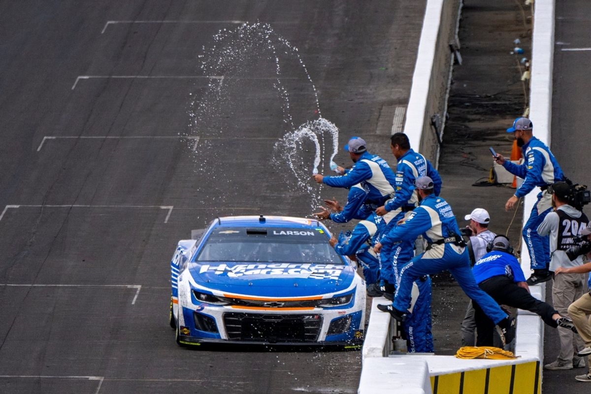 The crew of NASCAR Cup Series driver Kyle Larson (5) celebrate on the track after winning the 30th running of the Brickyard 400, Sunday, July 21, 2024, at Indianapolis Motor Speedway.