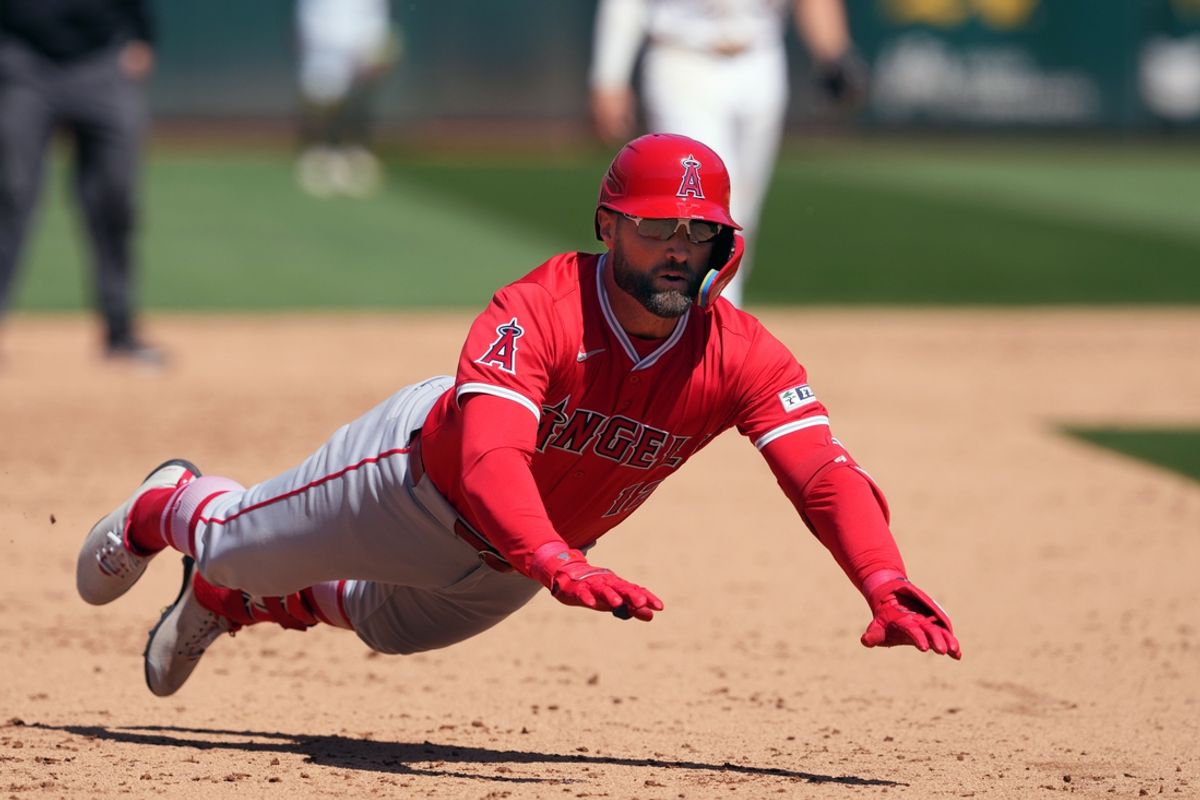 Jul 21, 2024; Oakland, California, USA; Los Angeles Angels center fielder Kevin Pillar (12) slides into third base after hitting an RBI-double against the Oakland Athletics during the eighth inning at Oakland-Alameda County Coliseum. Mandatory Credit: Darren Yamashita-USA TODAY Sports