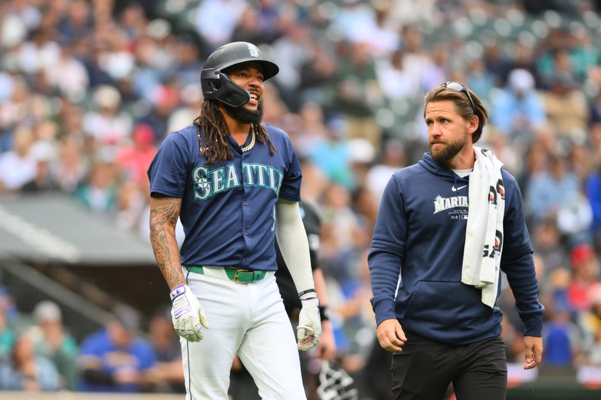 Jul 22, 2024; Seattle, Washington, USA; Seattle Mariners shortstop J.P. Crawford (3) walks to first base with trainer Kyle Torgerson after being hit by a pitch during the first inning against the Los Angeles Angels at T-Mobile Park. Mandatory Credit: Steven Bisig-USA TODAY Sports