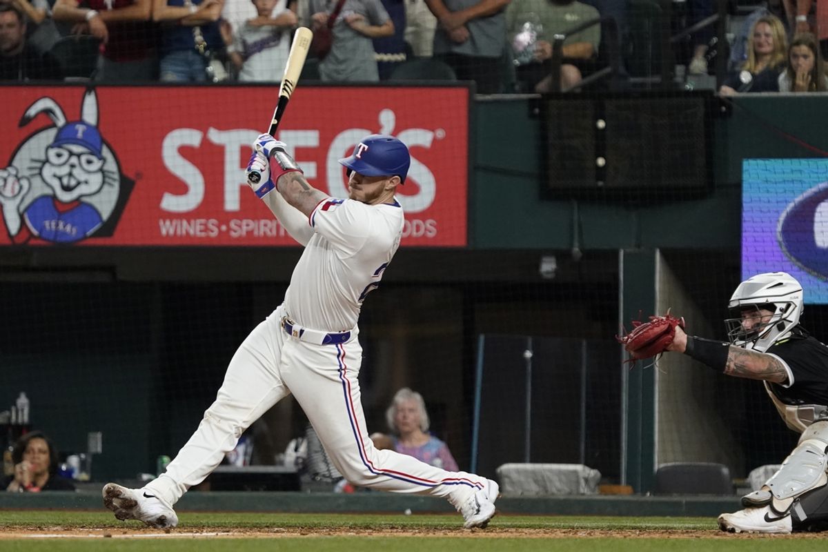 Jul 22, 2024; Arlington, Texas, USA; Texas Rangers catcher Jonah Heim (28) hits an RBI single during the ninth inning against the Chicago White Sox at Globe Life Field. Mandatory Credit: Raymond Carlin III-USA TODAY Sports