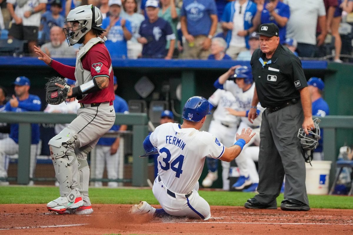 Jul 24, 2024; Kansas City, Missouri, USA; Kansas City Royals designated hitter Freddy Fermin (34) slides into home against the Arizona Diamondbacks in the second inning at Kauffman Stadium. Mandatory Credit: Denny Medley-USA TODAY Sports