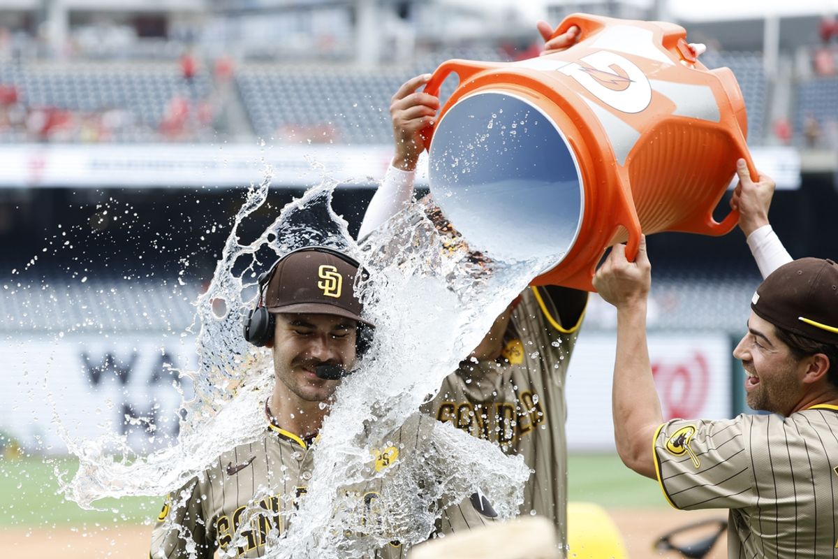 Jul 25, 2024; Washington, District of Columbia, USA; San Diego Padres pitcher Dylan Cease (84) is doused with a Gatorade cooler by Padres third baseman Manny Machado (13) and Padres third baseman Tyler Wade (14) while waiting for an on-air interview after throwing a no-hitter against the Washington Nationals at Nationals Park. Mandatory Credit: Geoff Burke-USA TODAY Sports