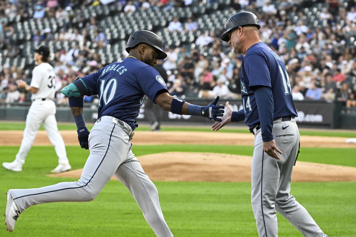 Jul 26, 2024; Chicago, Illinois, USA;  Seattle Mariners outfielder Victor Robles (10) high fives Seattle Mariners third base coach Manny Acta (14) after he homers against the Chicago White Sox during the first inning at Guaranteed Rate Field. Mandatory Credit: Matt Marton-USA TODAY Sports