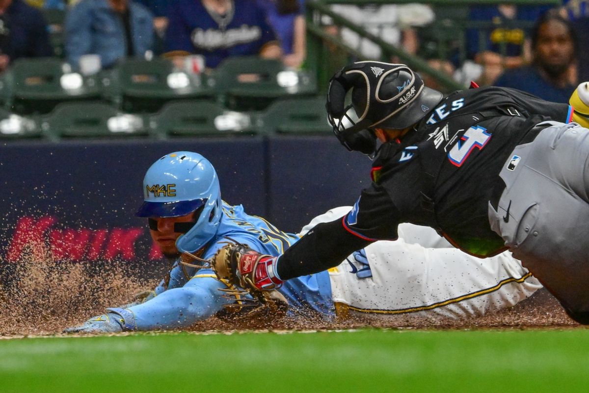 Jul 26, 2024; Milwaukee, Wisconsin, USA; Milwaukee Brewers catcher William Contreras (24) scores before tag by Miami Marlins catcher Nick Fortes (4) in the fourth inning at American Family Field. Mandatory Credit: Benny Sieu-USA TODAY Sports