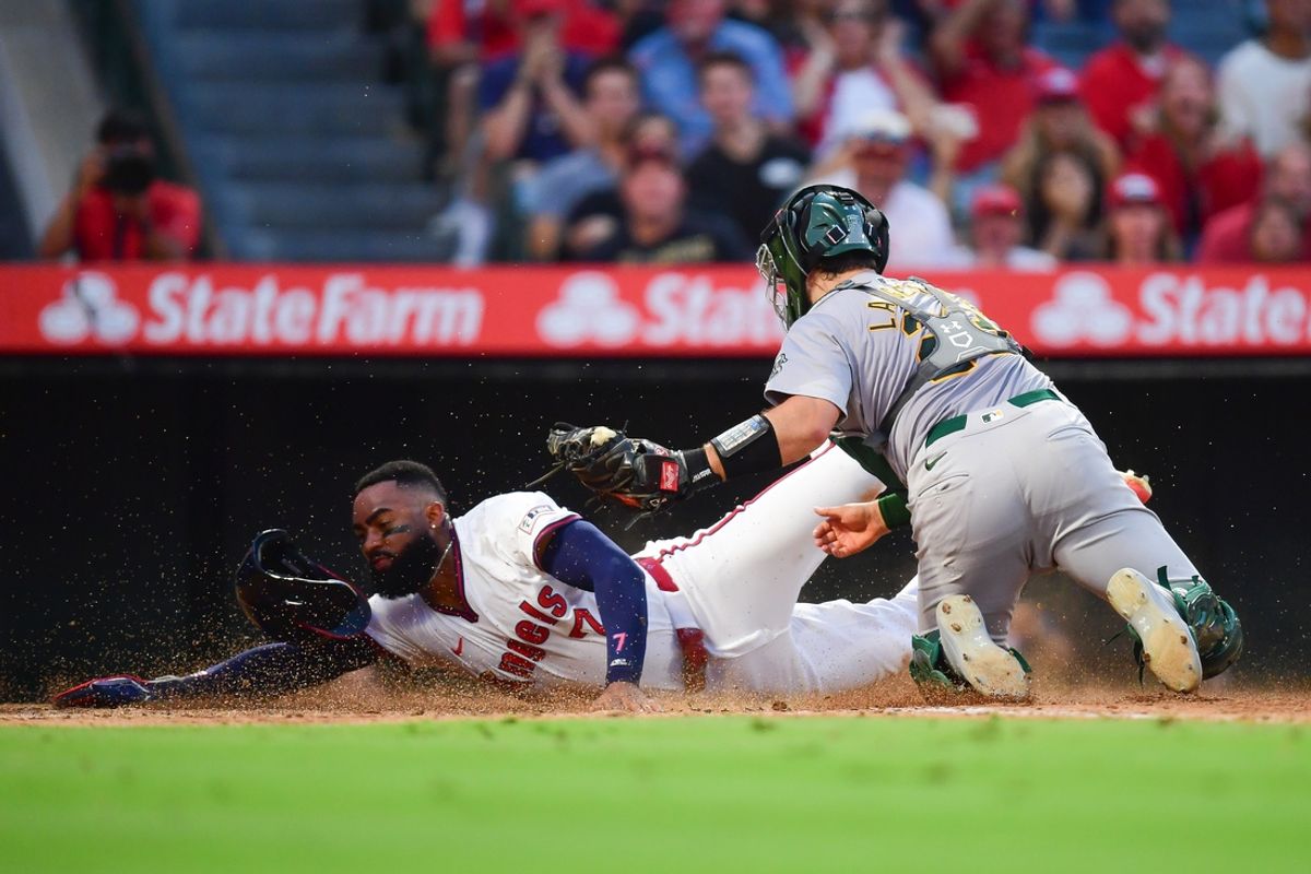 Jul 26, 2024; Anaheim, California, USA; Los Angeles Angels right fielder Jo Adell (7) is out at home against the tag of Oakland Athletics catcher Shea Langeliers (23) during the fifth inning at Angel Stadium. Mandatory Credit: Gary A. Vasquez-USA TODAY Sports